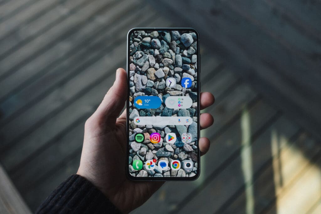 Hand holding Samsung Galaxy A56 showing home screen